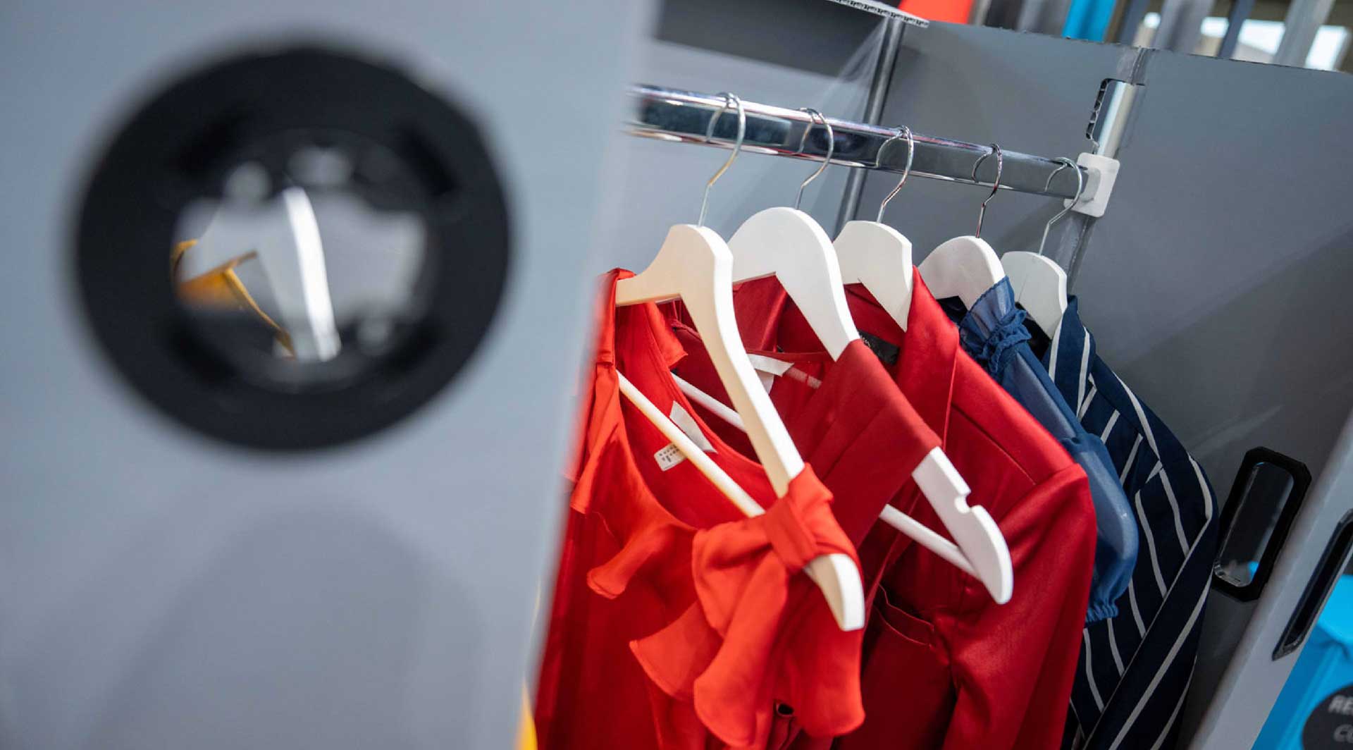 Kleiderstange mit Kleiderbügeln und Kleidung in Container