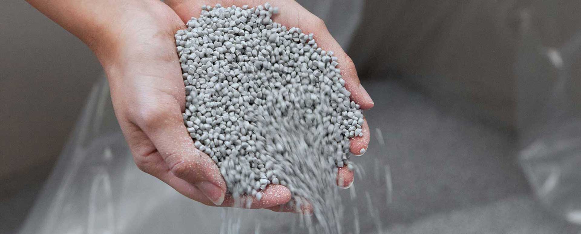 PP-Material rieselt durch zwei Hände