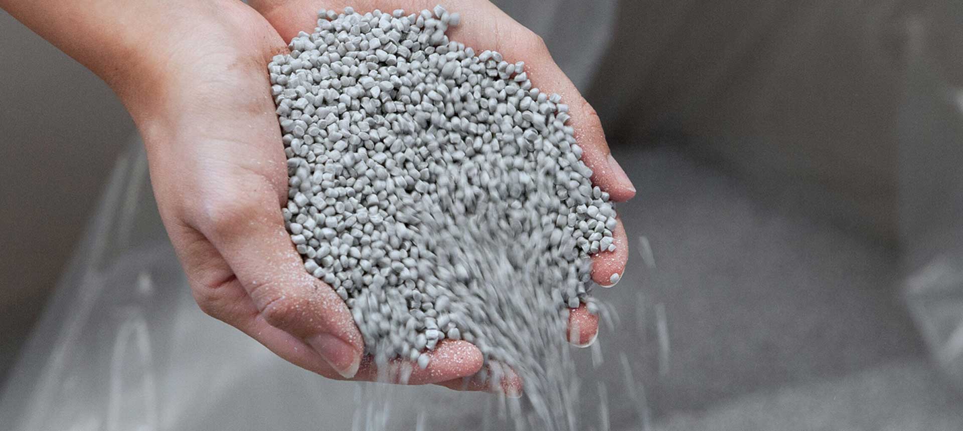 PP-Material rieselt durch zwei Hände